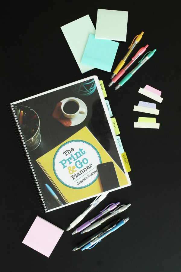 print and go planner on black table with post-its, tabs, and markers.