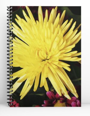 spiral notebook with black coil and a big yellow flower in the center.